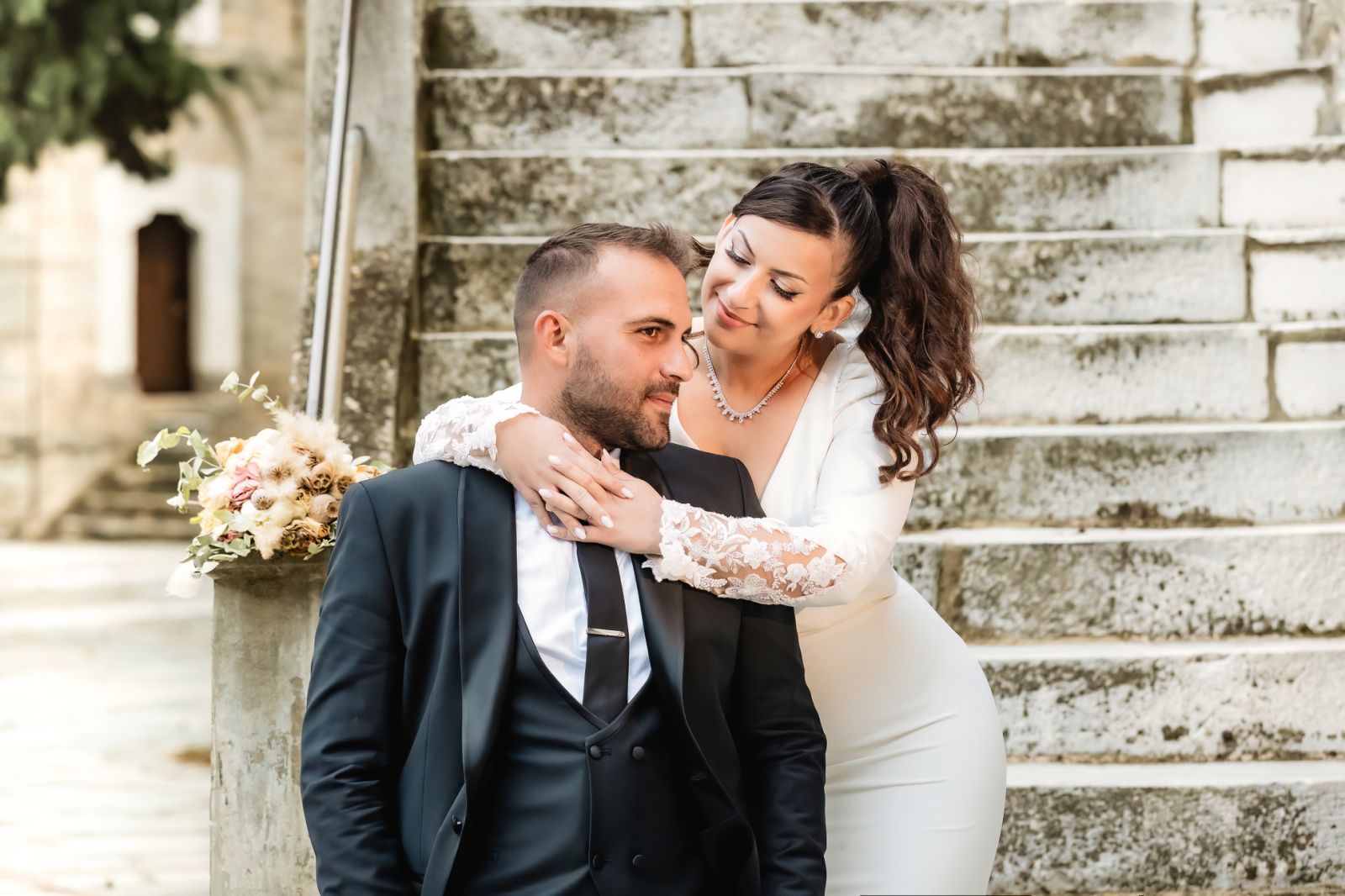 Bride embracing groom on stone steps